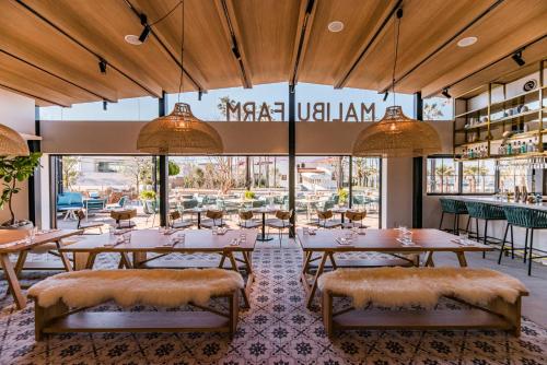 a restaurant with tables and chairs and large windows at MALIBU HOTEL in Zushi
