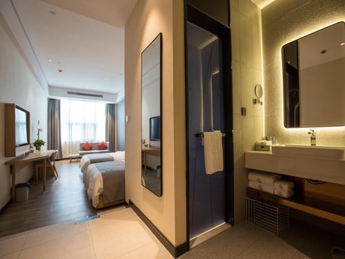 a hotel room with a bed and a bathroom at LanOu Hotel Heyuan Dongyuan Jianji University in Heyuan
