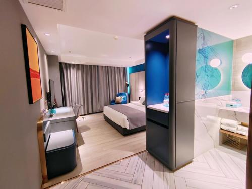 a hotel room with a bed and a bathroom at LanOu Hotel Bazhou Korla Jindu Plaza in Korla