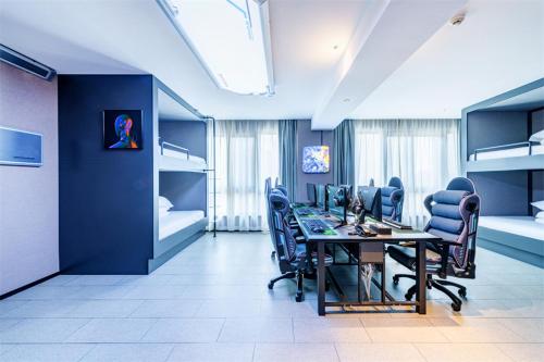 a room with a table and chairs and bunk beds at LanOu Hotel Zigong Yantan Longhu Food Plaza in Zigong