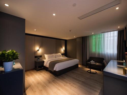 Habitación de hotel con cama, silla y escritorio. en LanOu Hotel Chaozhou Xiangqiao District Plaza, en Chaozhou