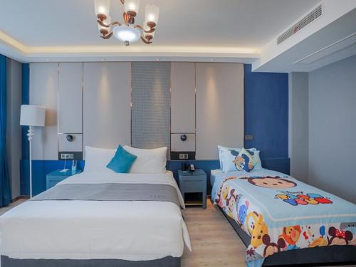 2 camas en un dormitorio con paredes azules en LanOu Hotel Taixing Wanda Plaza, en Taixing