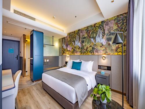 Cette chambre comprend un grand lit et un bureau. dans l'établissement LanOu Hotel Guilin Wanfu Plaza, à Guilin