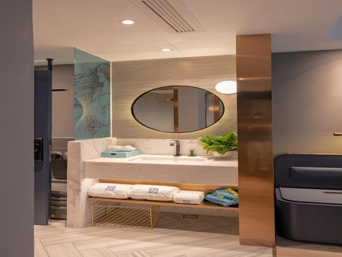 a bathroom with a sink and a mirror at LanOu Hotel Qingdao Huangdao District Xinjiekou in Huangdao