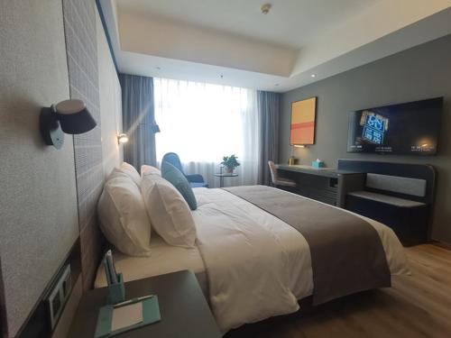 Habitación de hotel con cama grande y escritorio. en LanOu Hotel Shijiazhuang Luquan Zoo Scenic Spot, en Luquan