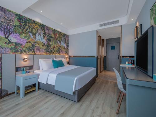 een hotelkamer met een groot bed en een flatscreen-tv bij LanOu Hotel Tai'an Taishan Railway Station in Tai'an