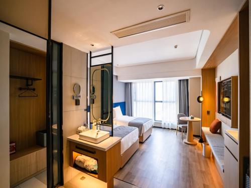 Habitación de hotel con cama y baño en LanOu Hotel Longkou Boshang Shopping Plaza, en Longkou