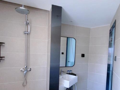 a bathroom with a shower and a sink and a mirror at LanOu Hotel Golmud Middle Bayi Road in Golmud