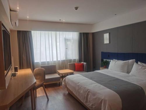 a hotel room with a large bed and a desk at LanOu Hotel Tianshui Bus Terminal Station in Tianshui