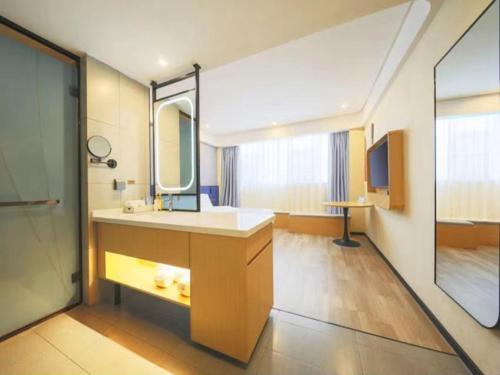 uma casa de banho com um lavatório e um espelho em LanOu Hotel Linyi Railway Station National Fitness Center em Linyi