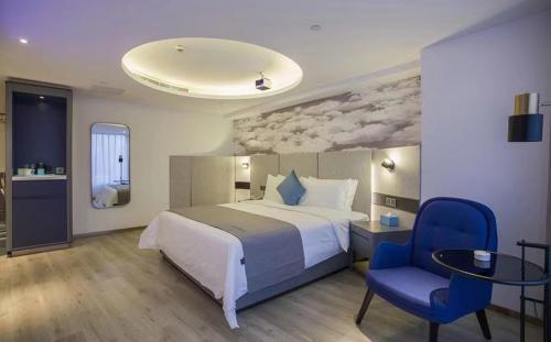a bedroom with a bed and a blue chair at LanOu Hotel Zhenjiang Runzhou District Railway Station in Zhenjiang