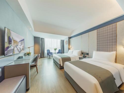 a hotel room with two beds and a desk at LanOu Hotel Linyi Lanshan Lushang Center Wanda Plaza in Linyi