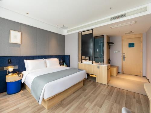 a bedroom with a large bed and a bathroom at LanOu Hotel Shanghai Sheshan National Forest Park Happy Valley in Songjiang
