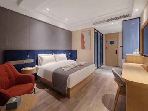 a bedroom with a large bed and a red chair at LanOu Hotel Qingdao Golden Beach Scenic Area in Huangdao