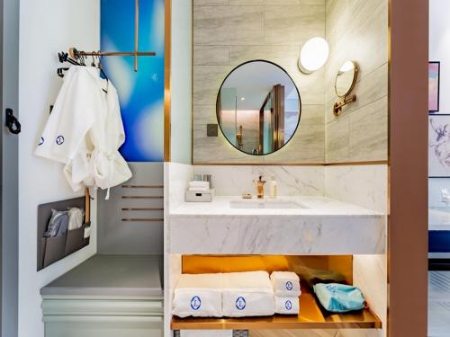 W łazience znajduje się umywalka, lustro i ręczniki. w obiekcie LanOu Hotel Hohhot New Town Moore City w mieście Hohhot