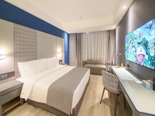 a hotel room with a large bed and a flat screen tv at LanOu Hotel Zhangye Hexi College Ganquan Park in Zhangye