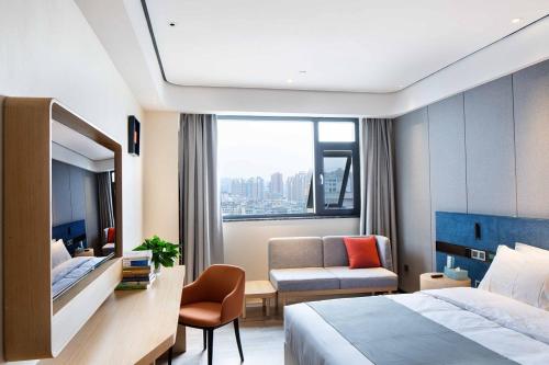 una camera d'albergo con letto e sedia di LanOu Hotel Tongren Wanshan Jinlin Avenue a Tongren