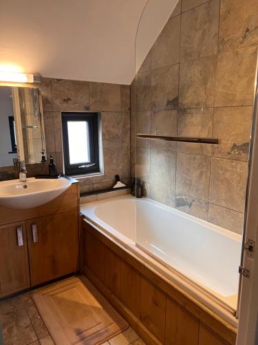 a bathroom with a white tub and a sink at The Annex at Meadow Farm in Cambridge