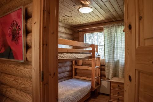 a bedroom with bunk beds in a log cabin at Saimaan Kultaranta in Puumala