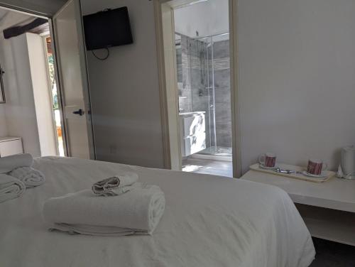 a white bed with two towels on top of it at Villaggio Camping Torre Del Porticciolo in Porto Conte
