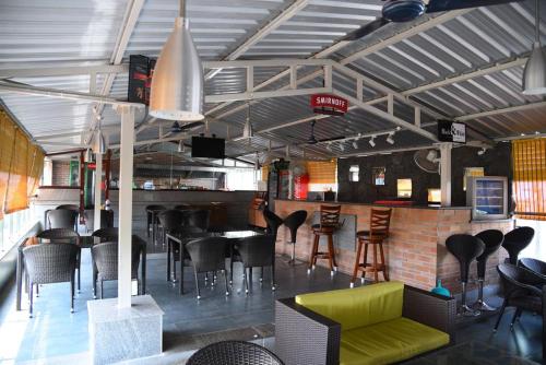 a restaurant with a bar with tables and chairs at HOTEL KING PARK in Puducherry