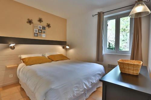 a bedroom with a bed and a table and a window at Le Bastidon de Guillemette in Gordes
