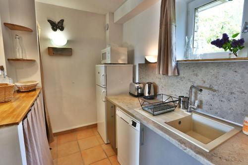 a kitchen with a sink and a refrigerator at Le Bastidon de Guillemette in Gordes