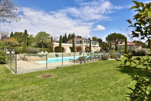 une maison avec une piscine dans une cour dans l'établissement Le Bastidon de Guillemette, à Gordes
