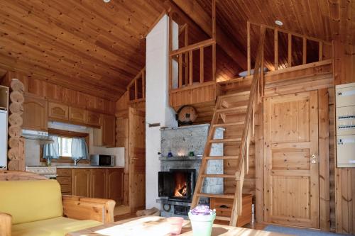 a living room with a fireplace in a log cabin at Saimaan Kultaranta in Puumala