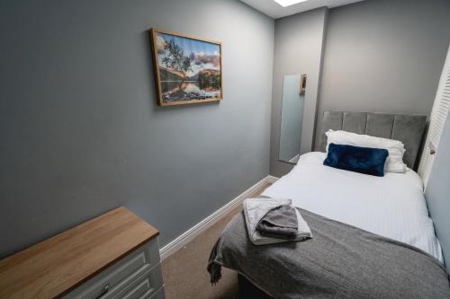 a small bedroom with a bed and a picture on the wall at Blue Anchor House in Maryport