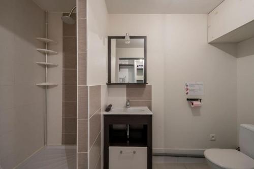 uma casa de banho com um lavatório, um espelho e um WC. em L'Ainstant em Bellegarde-sur-Valserine