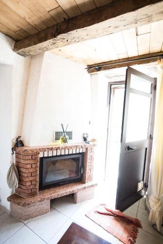 a brick fireplace in a living room with a door at Freelandros Villa in Nardodipace