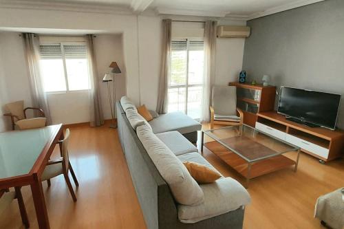 uma sala de estar com um sofá e uma televisão de ecrã plano em Piso con balcón La Alberca, Murcia em Múrcia