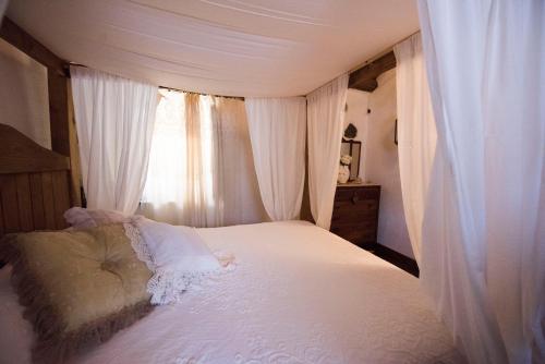 a bedroom with a white bed with a window at Freelandros Villa in Nardodipace
