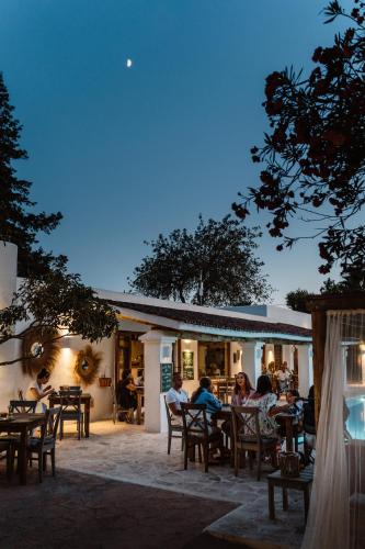 a group of people sitting at tables outside of a restaurant at Can Vistabella Boutique Resort in San Antonio