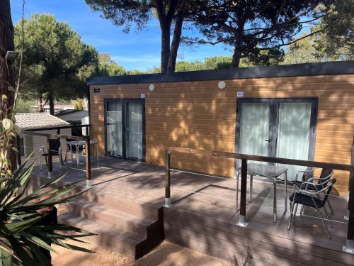 a tiny house with a deck with a table and chairs at Tres Estrellas in Gavà