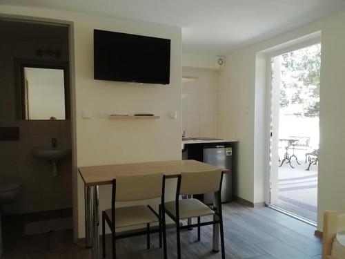 ein Wohnzimmer mit einem Tisch und Stühlen sowie einem TV an der Wand in der Unterkunft Agrowinnica in Borzytuchom