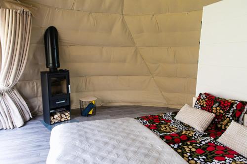 a bed in a tent with a wood stove at Igloo Glamping LakeLand Camp in Imatra