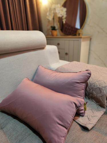 two pillows sitting on top of a bed at MP Villa with Cinema Room in Hock Lam Village