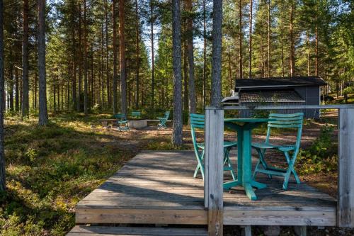 a table and chairs on a wooden deck with a grill at Saimaan Kultaranta in Puumala
