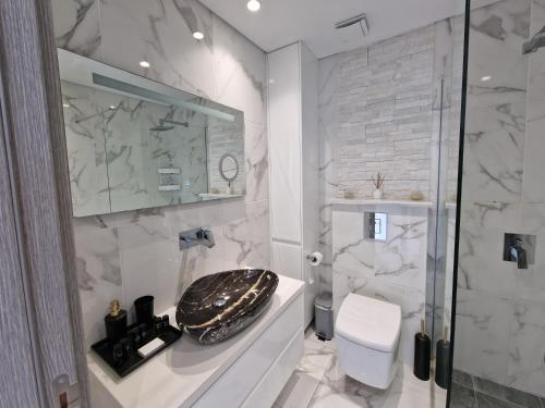 La salle de bains blanche est pourvue de toilettes et d'un lavabo. dans l'établissement The Belvedere Latchi Marina, à Latchi