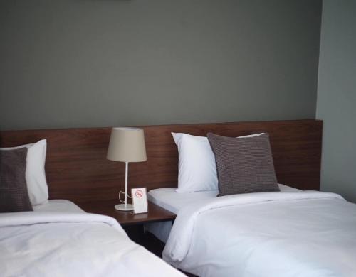 Ένα ή περισσότερα κρεβάτια σε δωμάτιο στο Thezen Hotel