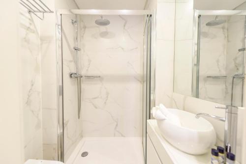 a white bathroom with a shower and a sink at Braga Center Apartments - São Vicente in Braga