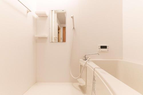 大阪的住宿－miyu 灵谷 デザイナーズ和の空間友達グループ最適ゲーム室完備新しいオープン，白色的浴室设有浴缸和镜子