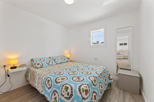 ein weißes Schlafzimmer mit einem Bett und einem Fenster in der Unterkunft Famara Loft 12 in Famara