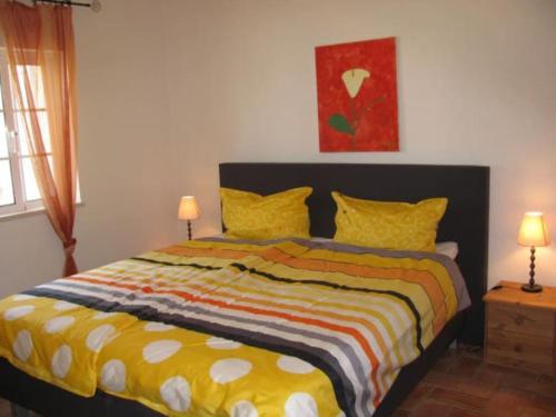 a bedroom with a bed with a colorful blanket at Vivenda Vista Verde in Portimão