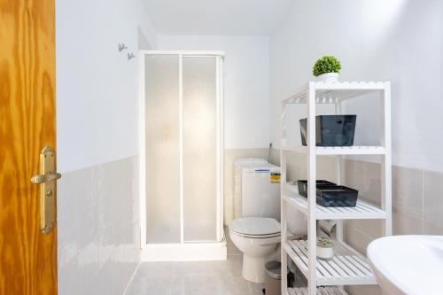 a bathroom with a toilet and a tv on a shelf at Home2Book Dream Apartment Blue Coast Sun Fañabé in Adeje
