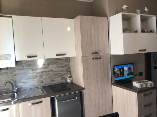 a kitchen with white cabinets and a sink and a stove at Nenè al mare appartamento con posto auto wifi e idromassaggio in Santa Margherita Ligure