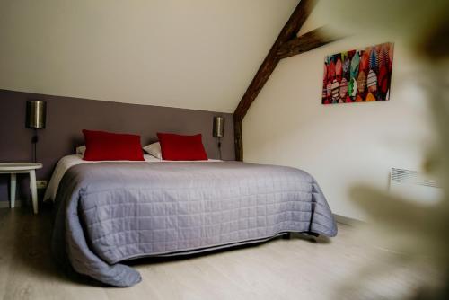 a bedroom with a large bed with two red pillows at Appart'hotel Durbuy in Durbuy