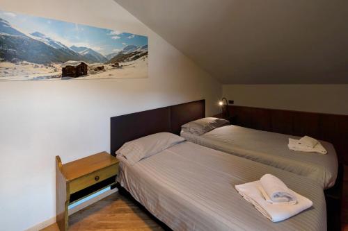 een slaapkamer met 2 bedden en een foto aan de muur bij Casa Marcos n 35 in Livigno